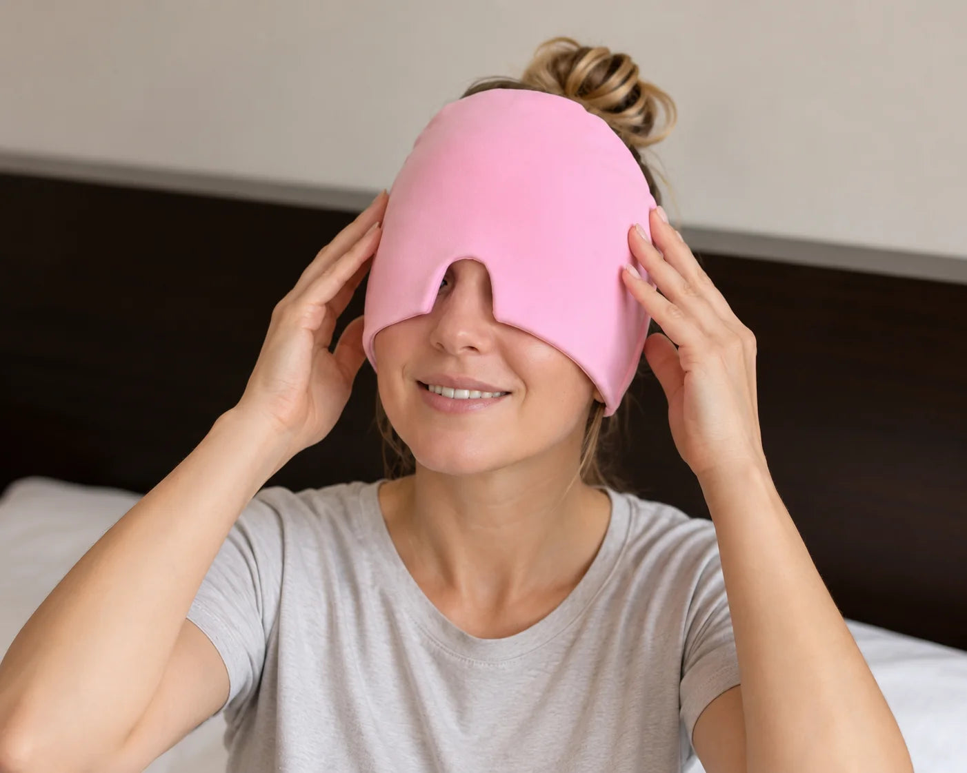 A woman gently positioning a pink NuraCool cap